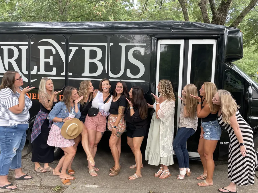 Bride and friends blowing kisses beside the Barley Bus