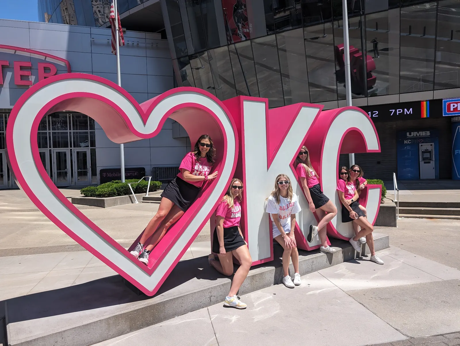 Bachelorette party in pink shirts at the Heart KC sign in Kansas City