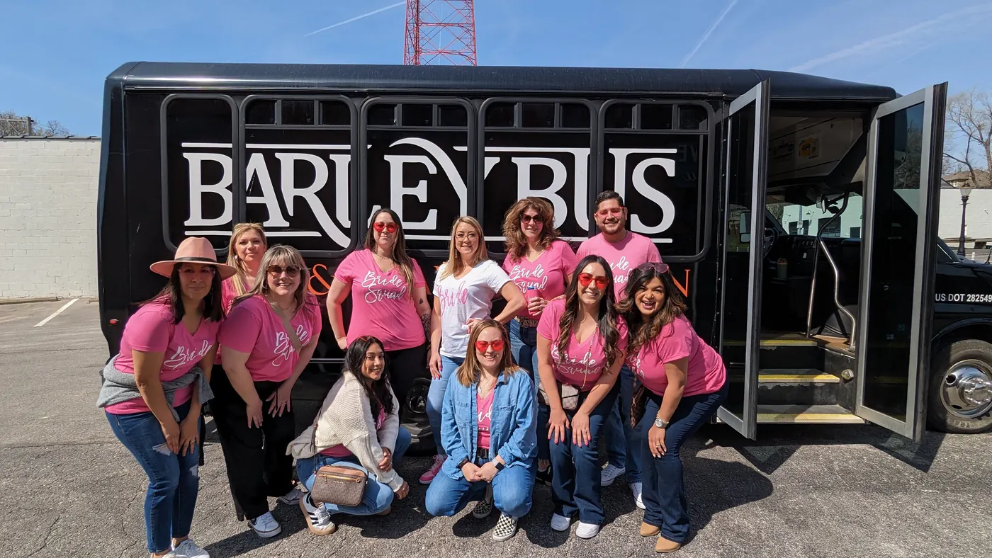 Bachelorette group in matching pink shirts in front of the Barley Bus