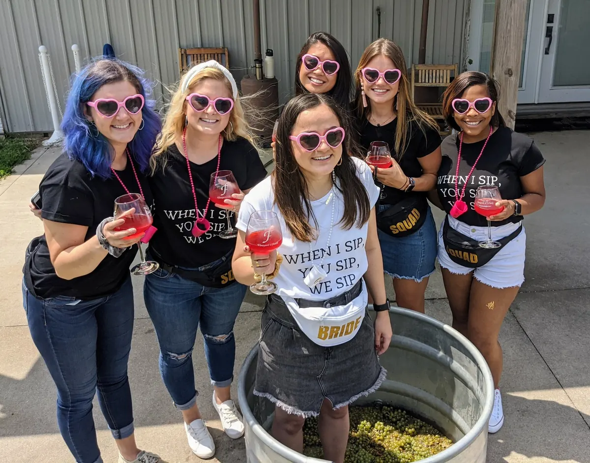Bachelorette group in matching shirts toasting at a Kansas City winery